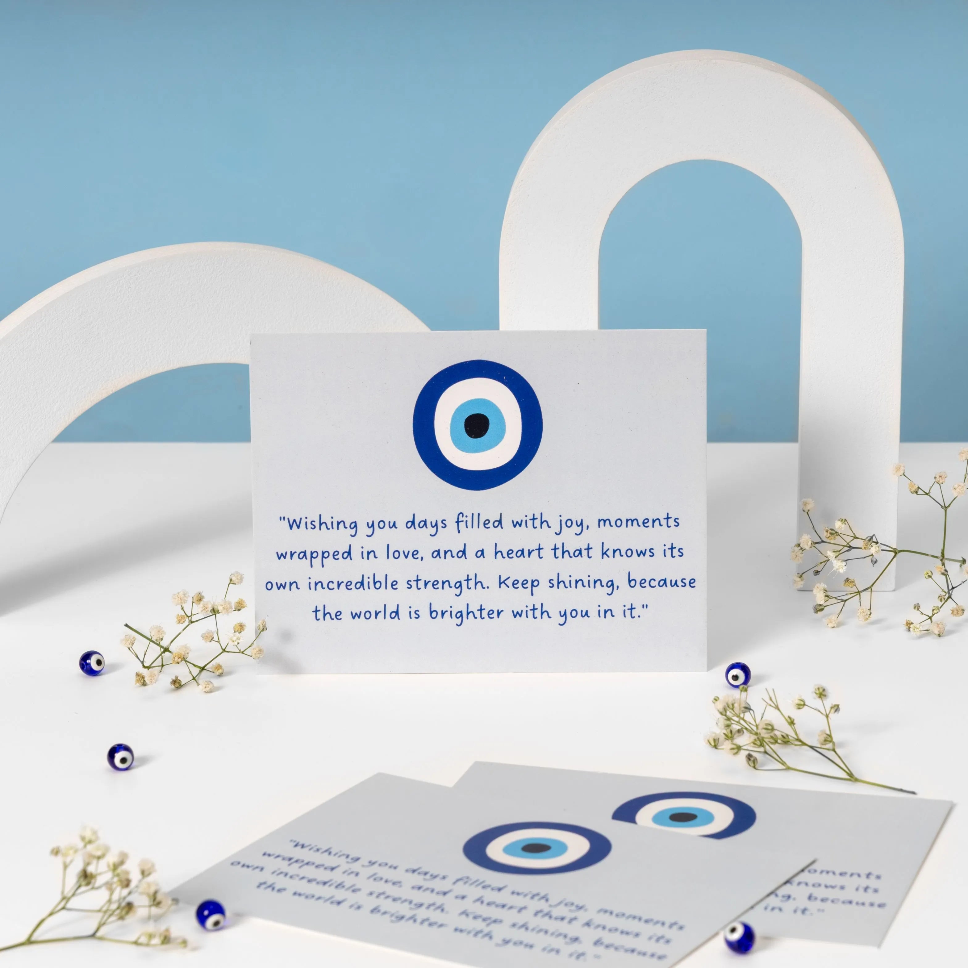 Evil Eye themed greeting card with a blue and white evil eye design and heartfelt message wishing joy, love, strength, and happiness.