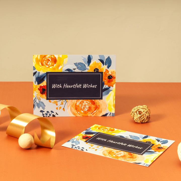 Floral card with 'With Heartfelt Wishes' text on an orange surface with decorative elements.