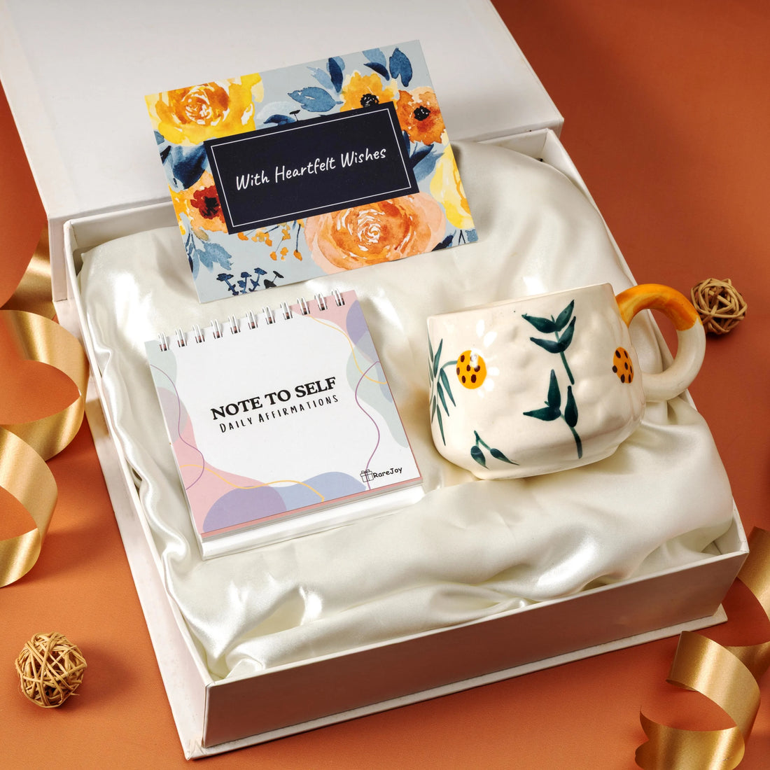 Rarejoy gift hamper featuring a floral ceramic mug, daily affirmations notepad, and heartfelt greeting card in a premium white gift box, perfect for birthdays, thank you gifts, and self-care.