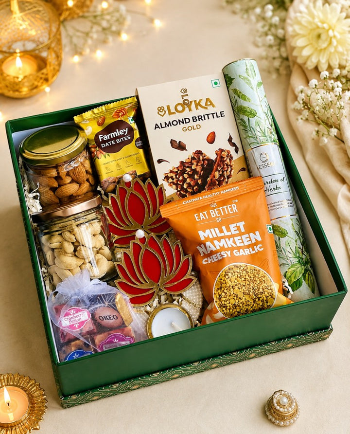 Premium Diwali gift hamper featuring assorted dry fruits, healthy snacks, almond brittle, chocolates, decorative lotus diyas and herbal products, beautifully arranged in an elegant green gift box.