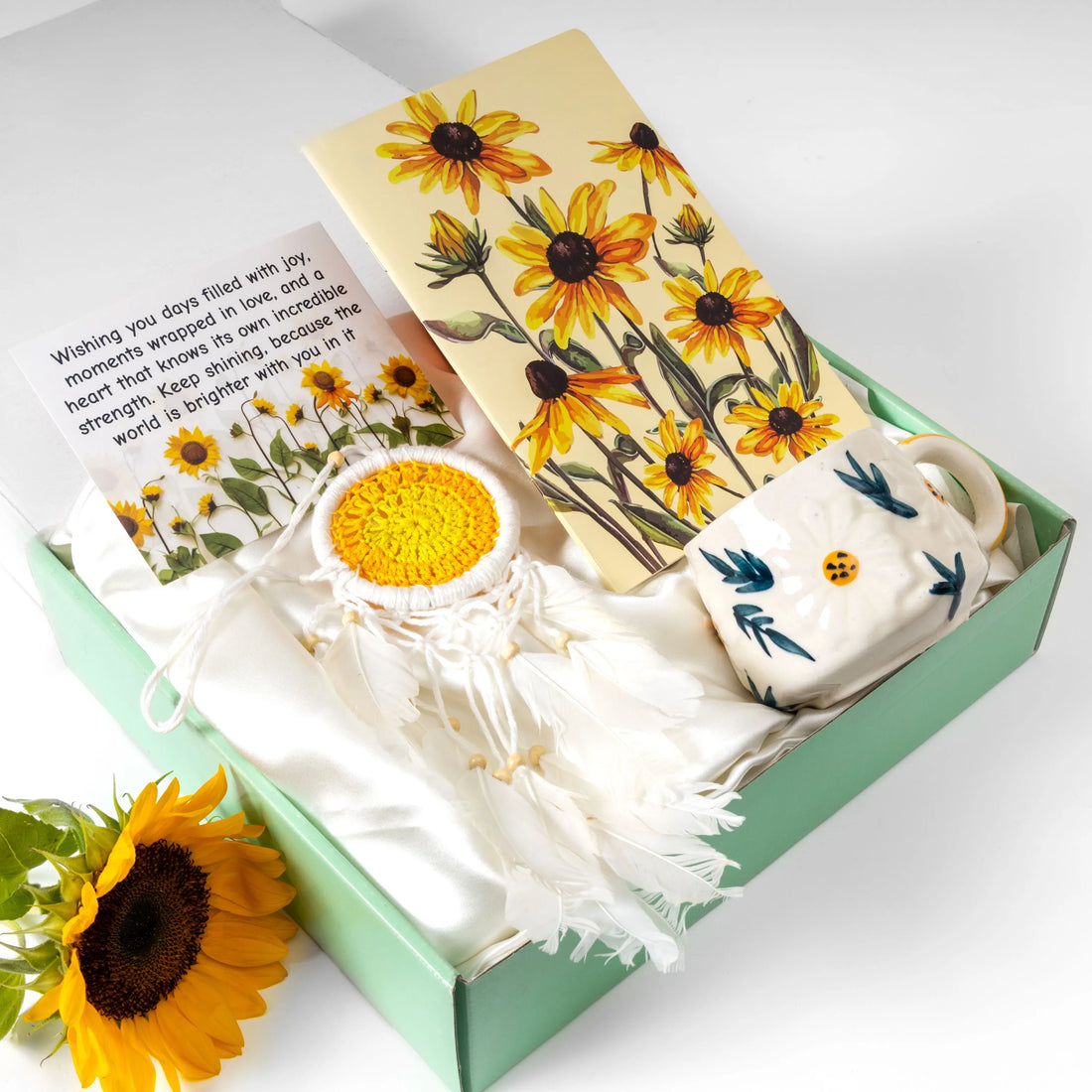 Sunflower-themed gift hamper with floral notebook, handmade dreamcatcher, ceramic mug and inspirational greeting card