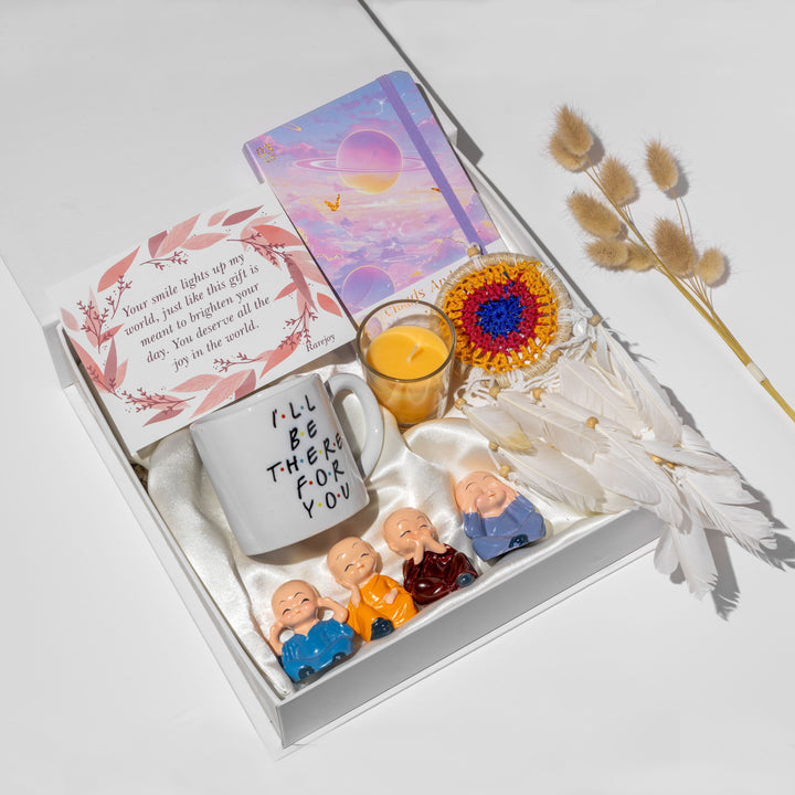 Gift set with mug, candles, and figurines on a white surface