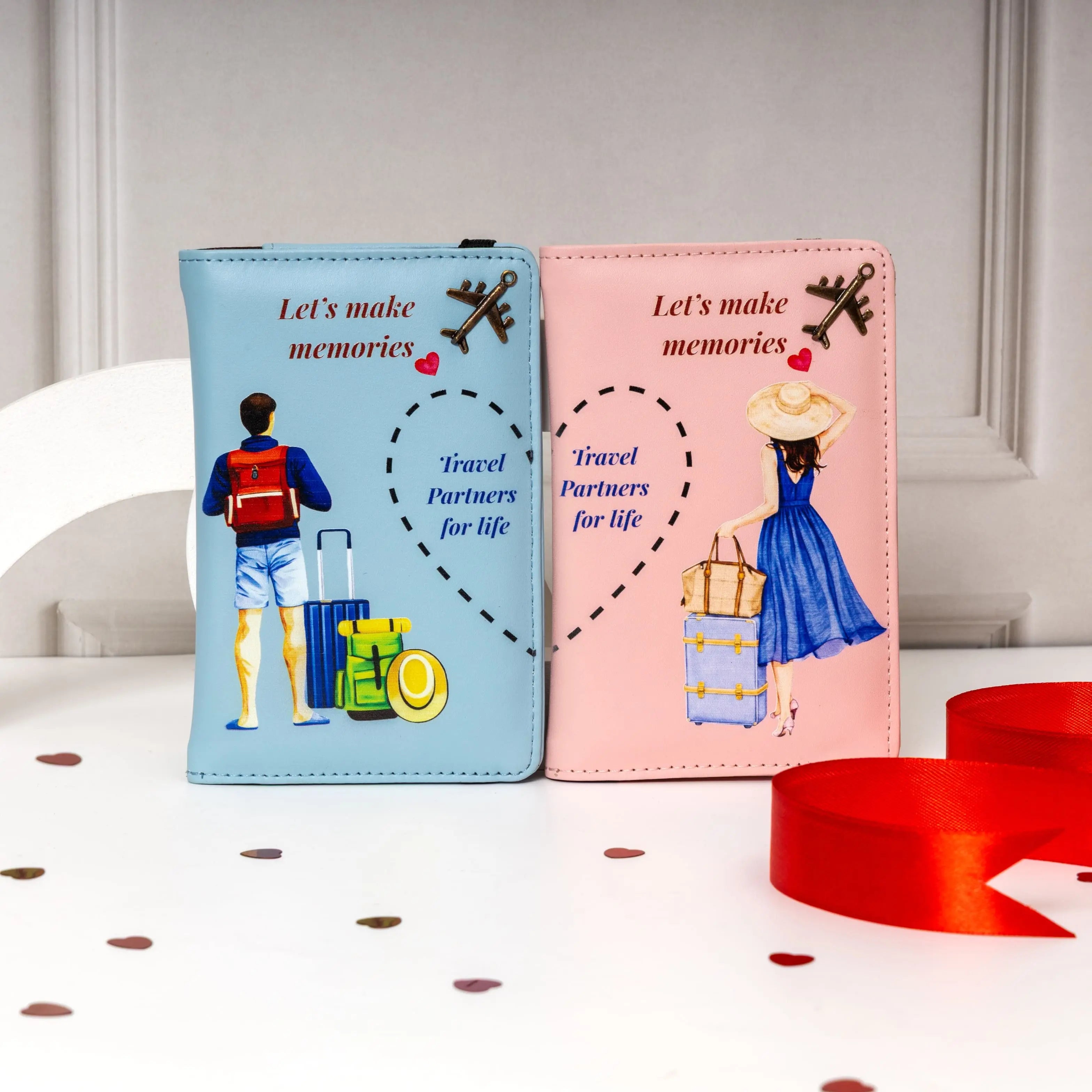 Two travel-themed passport holders, one blue and one pink, with illustrations of people and luggage on a white surface. Best for Couple Gift. Marraige Gift, Travelling kit