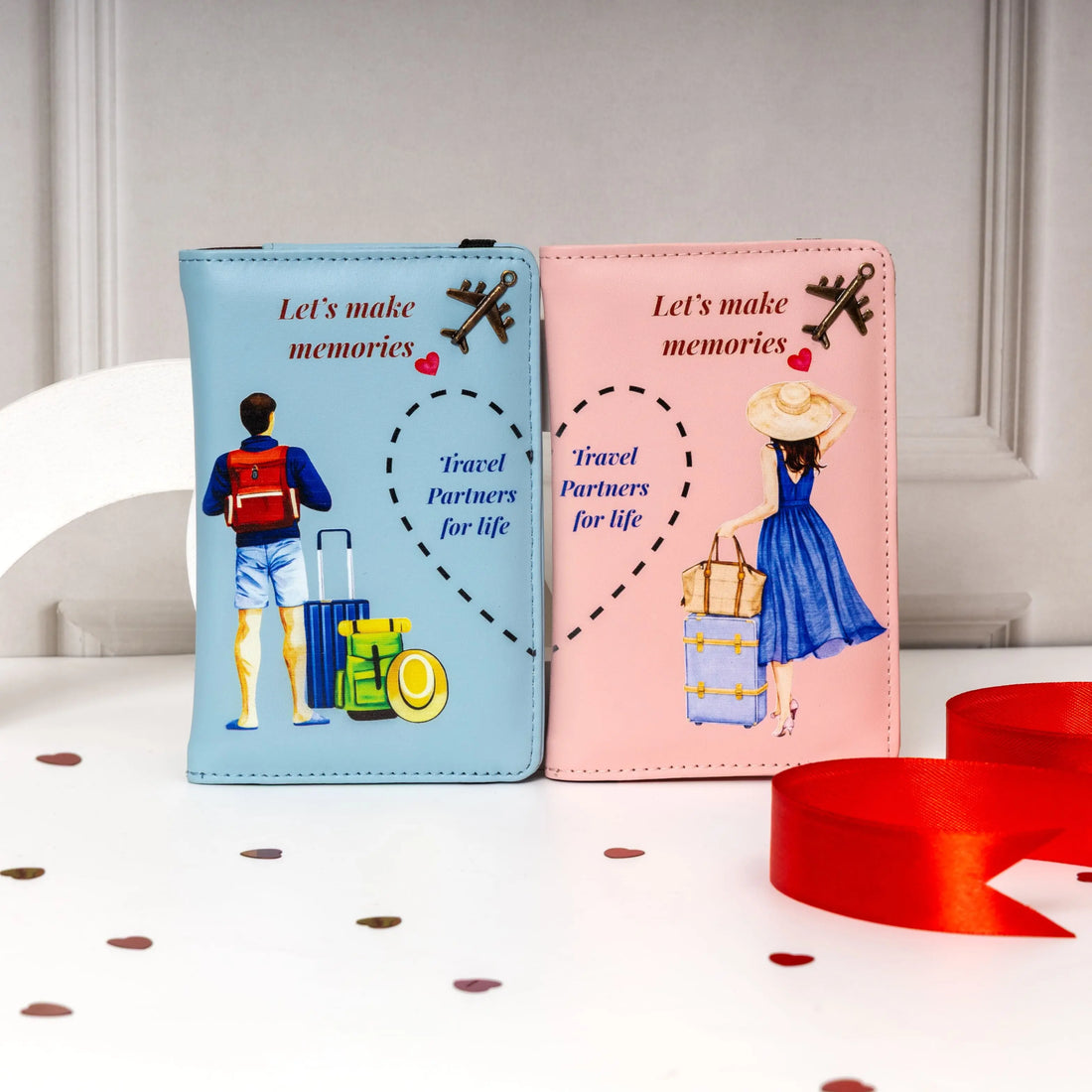 Two travel-themed passport holders, one blue and one pink, with illustrations of people and luggage on a white surface. Best for Couple Gift. Marraige Gift, Travelling kit