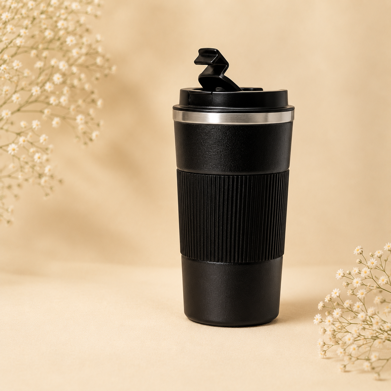 A black insulated travel tumbler with a textured grip and flip-top lid.