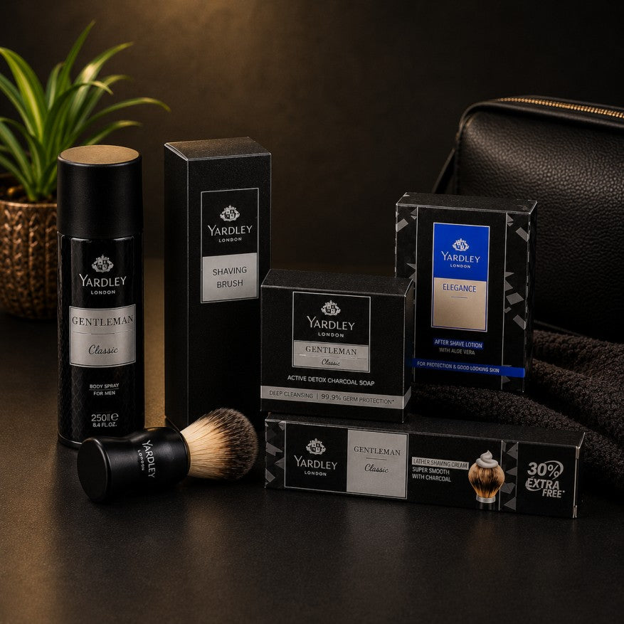 Yardley London men's grooming gift set featuring Gentleman Classic body spray, shaving brush, activated charcoal soap, after shave lotion, and shaving cream arranged on a premium black studio background.