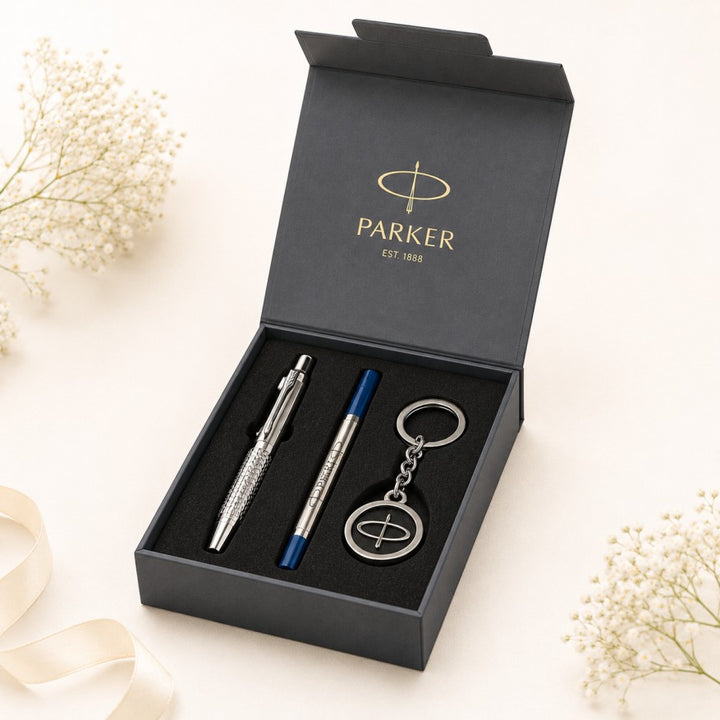 A Parker gift set in an open black presentation box, containing a silver ballpoint pen, a blue and silver ballpoint pen, and a matching silver keychain.